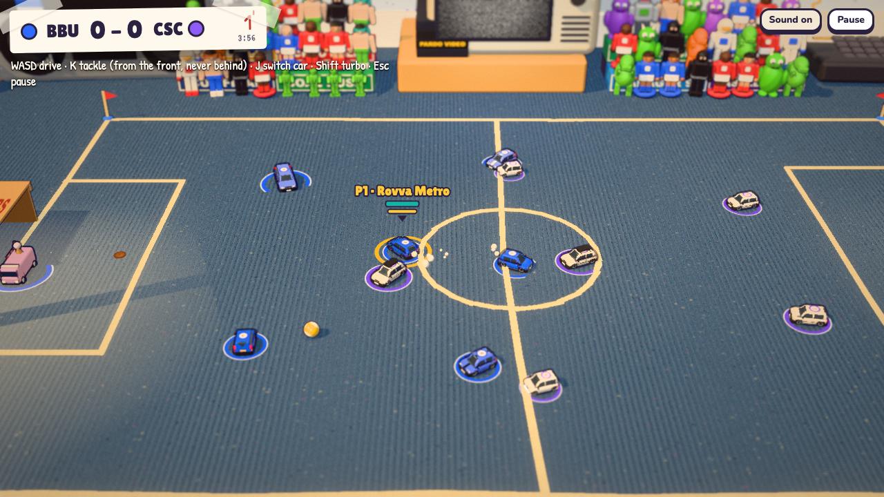 Car Football in play: radio-controlled toy cars and a small pool ball on a slate blue cord carpet, with a crowd of toy figures behind the pitch