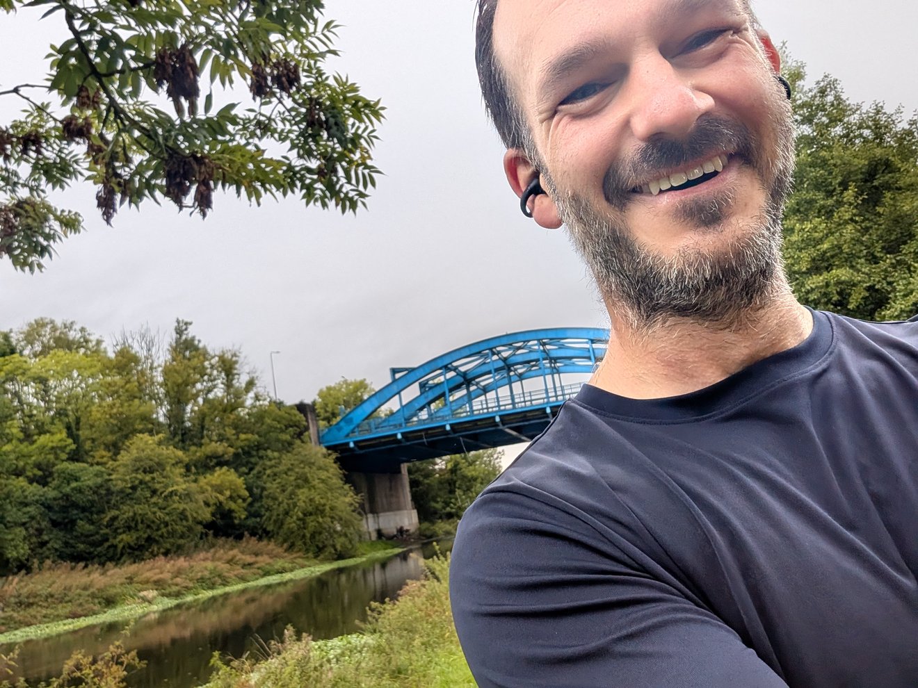 Selfie in front of the blue arch bridge over the river